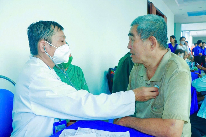 Bác sĩ thuộc Hội Quân dân Y Việt Nam đang ân cần thăm khám, chẩn đoán bệnh và tư vấn sức khỏe cho một cụ ông tại xã Đất Đỏ trong chương trình chăm sóc y tế nhân đạo tại địa phương