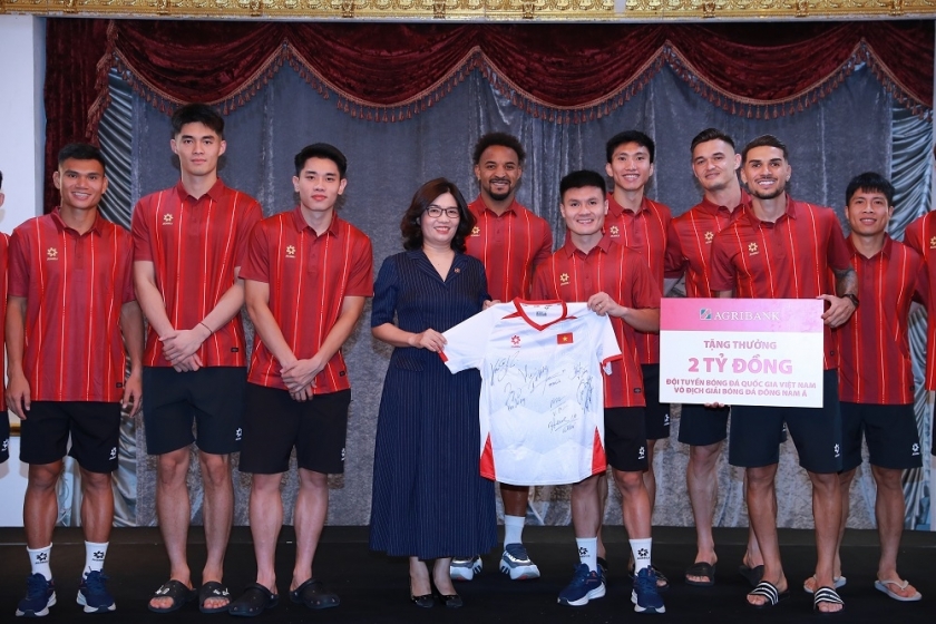 Cầu thủ Nguyễn Quang Hải, đại diện cho Đội tuyển Bóng bá Nam Việt Nam tặng chiếc áo đấu có chữ ký của các cầu thủ cho đại diện Agribank.