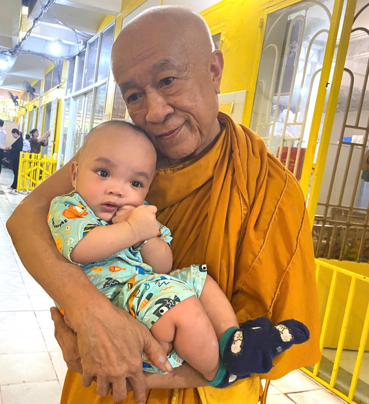 Thượng tọa Thích Minh Chiếu, trụ trì Chùa Kỳ Quang 2, ân cần ôm một em nhỏ được nhà chùa chăm sóc Thượng tọa Thích Minh Chiếu, trụ trì Chùa Kỳ Quang 2, ân cần ôm một em nhỏ được nhà chùa chăm sóc