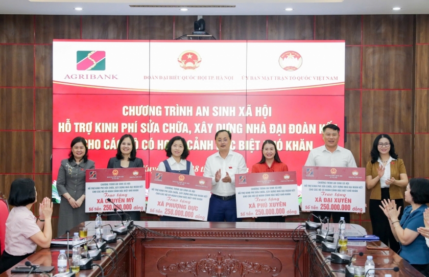 Đồng chí Tô Huy Vũ trao biểu trưng 1 tỷ đồng của Agribank hỗ trợ sửa chữa, xây dựng Nhà Đại đoàn kết cho các hộ gia đình có hoàn cảnh đặc biệt khó khăn tại 4 xã Phú Xuyên, Chuyên Mỹ, Phượng Dực và Đại Xuyên.