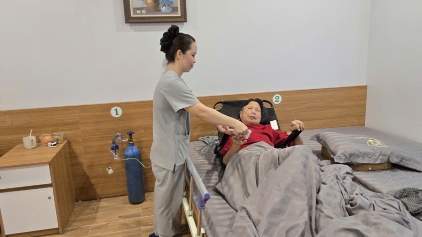 Cụ Lưu Thị Kỳ đang được các điều dưỡng viên của Trung tâm dưỡng lão trường thọ Xuân Hoa chăm sóc.
