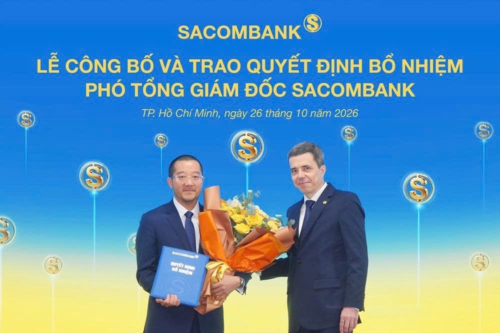 Ông Nguyễn Xuân Ái Quốc nhận quyết định bổ nhiệm và hoa chúc mừng từ ông Loic Faussier - Tổng giám đốc SACOMBANK (ảnh STB)